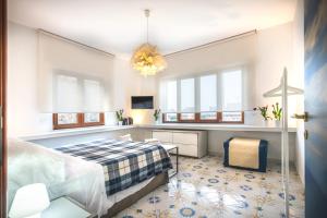 1 dormitorio con 1 cama, TV y ventanas en Sorrento Central Flat en Sorrento