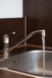 a sink with water coming out of a faucet at Orange Hotel und Apartments in Neu-Ulm