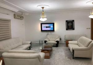 sala de estar con 2 sofás y TV en شقة مفروشة 4غرف نوم شارع الجامعة, en Amán