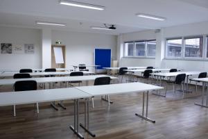 an empty room with tables and chairs in it at Orange Hotel und Apartments in Neu Ulm
