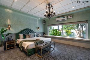 a bedroom with a bed and a window and a chandelier at EKOSTAY Luxe - CASABLANCA VILLA in Igatpuri