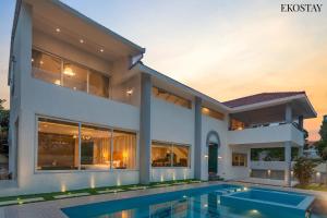 a house with a swimming pool in front of it at EKOSTAY Luxe - CASABLANCA VILLA in Igatpuri