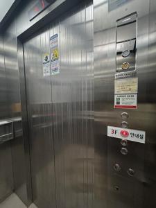un ascensor de metal con letreros en el costado. en Vision motel en Geoje 