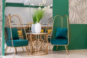 two chairs and a table with a vase on it at El Ocaso Boutique Hotel in Ho Chi Minh City