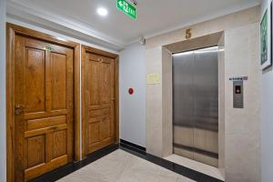 a hallway with two wooden doors and a elevator at El Ocaso Boutique Hotel in Ho Chi Minh City