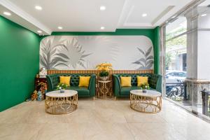 a living room with two green chairs and two tables at El Ocaso Boutique Hotel in Ho Chi Minh City