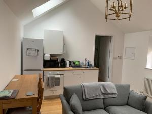a living room with a couch and a table and a kitchen at Brand new annexe on border of the Southdowns. in Waterlooville