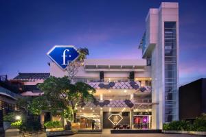 a large white building with a large letter t on it at Fashion Hotel Legian in Legian