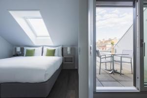 sypialnia z łóżkiem oraz balkon ze stołem w obiekcie Base Nyon w mieście Nyon