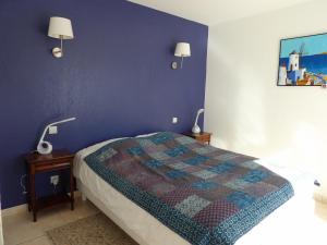 une chambre avec un lit et un mur bleu dans l'établissement St Cyprien Magnifique villa avec piscine, à Saint-Cyprien