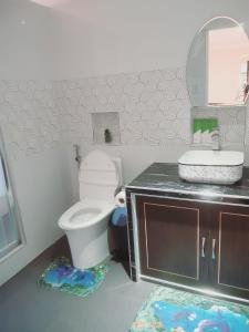 a bathroom with a toilet and a sink and a mirror at Avana Hills Boracay Prime Premium Suite 103 in Boracay