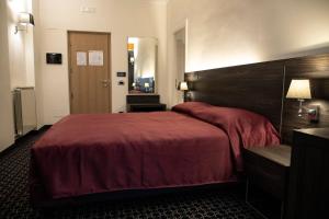 ein Schlafzimmer mit einem großen Bett mit einer roten Decke in der Unterkunft Gemelli Hotel in Rom