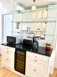 a kitchen with a black counter top with a microwave at T3 Terrasse près de la plage in Nice