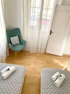 a room with two beds and a chair and a door at Saint Philippe - T3 Terrasse près de la plage in Nice
