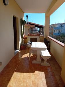 - Balcón con mesa blanca y sillas en City center apartment, en Le Castella