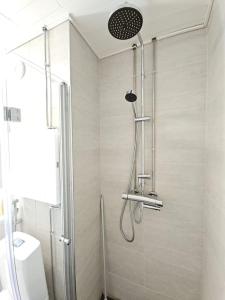 a shower stall in a bathroom with a toilet at Modern One-Bedroom with glazed sun balcony, 350m metro in Helsinki
