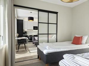 a bedroom with two beds and a room with a desk at Modern One-Bedroom with glazed sun balcony, 350m metro in Helsinki