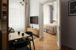 mały pokój z łóżkiem i stołem oraz pokój z tableablish w obiekcie R16 Residences Prague w Pradze
