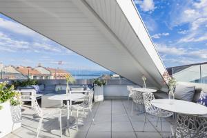 a balcony with tables and chairs on a roof at Base Nyon in Nyon