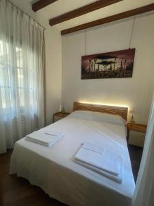 une chambre avec un lit blanc avec deux serviettes dessus dans l'établissement Bella Ciao Old Town, à Bergame