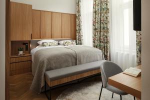 a bedroom with a bed and a chair and a table at R16 Residences Prague in Prague