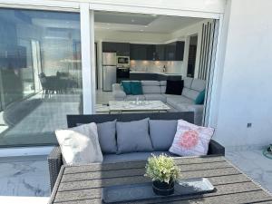 ein Wohnzimmer mit einem Sofa auf einer Terrasse in der Unterkunft Kasaj Luxury Apartments in Porto Rafti