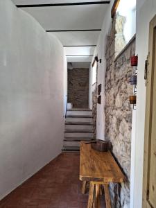 un couloir avec une table en bois et un mur en pierre dans l'établissement Casetta al Parione, à Bolsena
