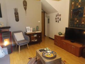 a living room with a television and a chair at Casa da Porta de Santo António in Bragança