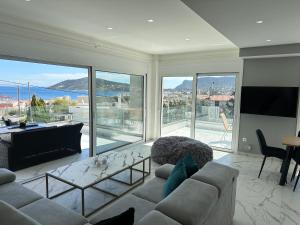 a living room with a couch and a large window at Kasaj Luxury Apartments in Porto Rafti