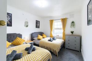 a bedroom with two beds and a couch at Open Mind Property - Southsea with Free Parking in Portsmouth