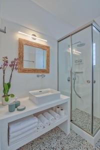 une salle de bain blanche avec lavabo et douche dans l'établissement Agapi's Houses, à Andiparos 135 autres photos