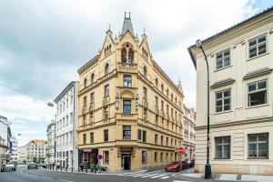 プラハにあるDesigned Spacious Flat with 2 Bedroms and Balconyの市道に塔のある高層ビル