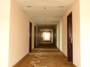 un pasillo vacío en un edificio con un pasillo largo en Yidun Hotel Foshan Luocun en Huanshi