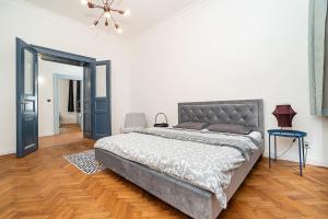 a bedroom with a large bed and a wooden floor at Designed Spacious Flat with 2 Bedroms and Balcony in Prague