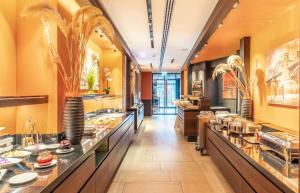 a large kitchen with a long line of counters at PLAZA INN Köln Pulheim in Pulheim