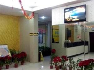 un hall d'entrée avec des fleurs et une télévision dans un immeuble dans l'établissement Shantou Jun Yue Business Hotel Tongyi Road Branch, à Batou