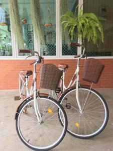 dos bicicletas estacionadas una junto a la otra frente a un edificio en Muanmanee Boutique Hotel en Loei