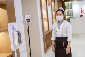 a woman in a pharmacy wearing a mask at Le President Hotel in Phnom Penh