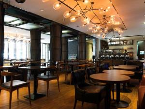 un restaurante con mesas y sillas y un bar en H Life Hotel, en Shenzhen