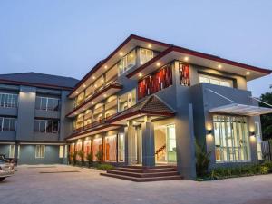 a large apartment building with a car parked in front at Soontree House Hotel in Udon Thani