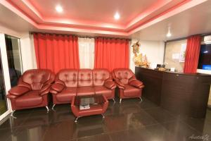 a living room with two leather chairs and a table at Nan Treasure Hotel in Ban Hua Wiang Nua