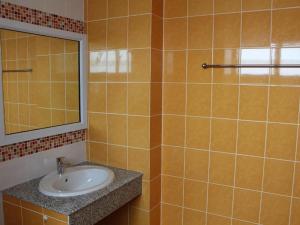 La salle de bains est pourvue d'un lavabo et d'un miroir. dans l'établissement The Grace Residence, à Surin