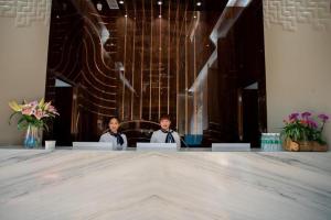 two people sitting at a large table in a room at Tomeet Hotel in Meizhou