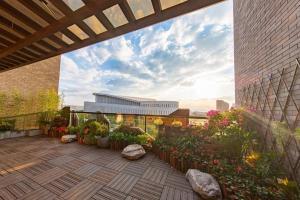 a patio with flowers and plants on a building at Tomeet Hotel in Meizhou