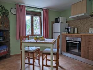 a kitchen with a table and chairs and a refrigerator at Casa Molily in Llanes