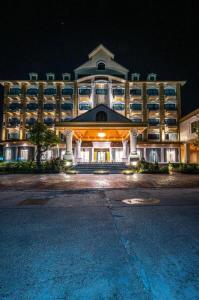 a large hotel building at night with a parking lot at HOTEL MUQ in Mukdahan