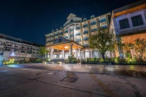 un gran edificio con una fachada iluminada por la noche en HOTEL MUQ, en Mukdahan
