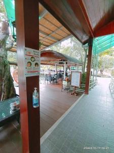 une terrasse couverte avec une table et des chaises. dans l'établissement Malang Por Hotel, à Ban Yuan