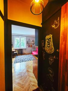 華沙的住宿－Art Murano，走廊,门上有一扇门,通往墙上绘有图纸的房间