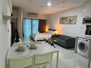 un soggiorno con letto e un tavolo di Mercu Summer Suites KLCC By Moonlight a Kuala Lumpur